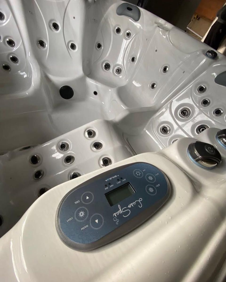 White jacuzzi interior with control panel and jets.