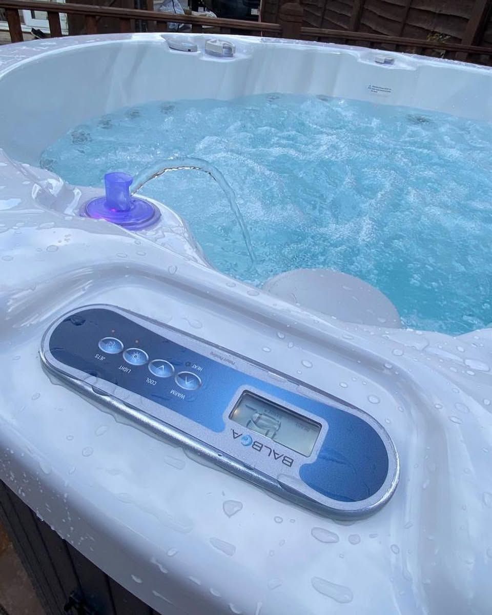 Hot tub with bubbling water and control panel; Balboa brand.