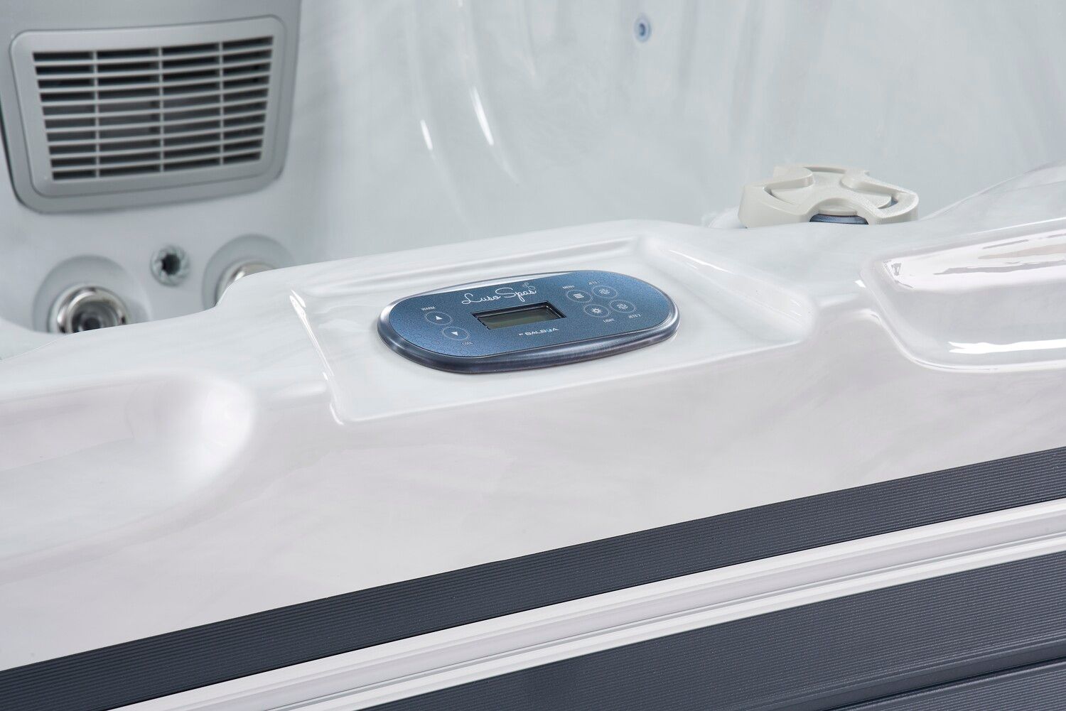 Hot tub interior with control panel and air vent.