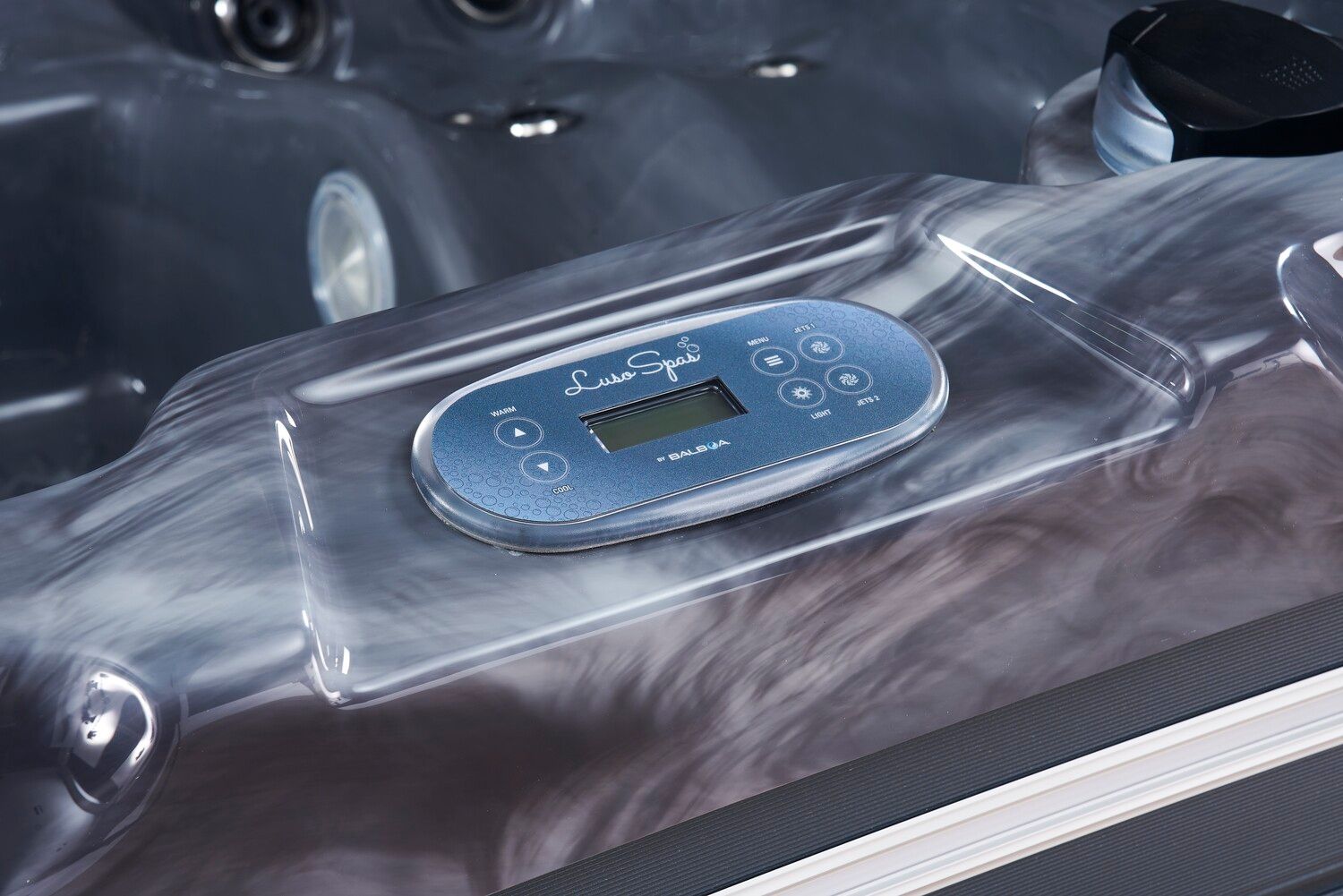 Spa control panel with buttons and display embedded in the tub’s surface.