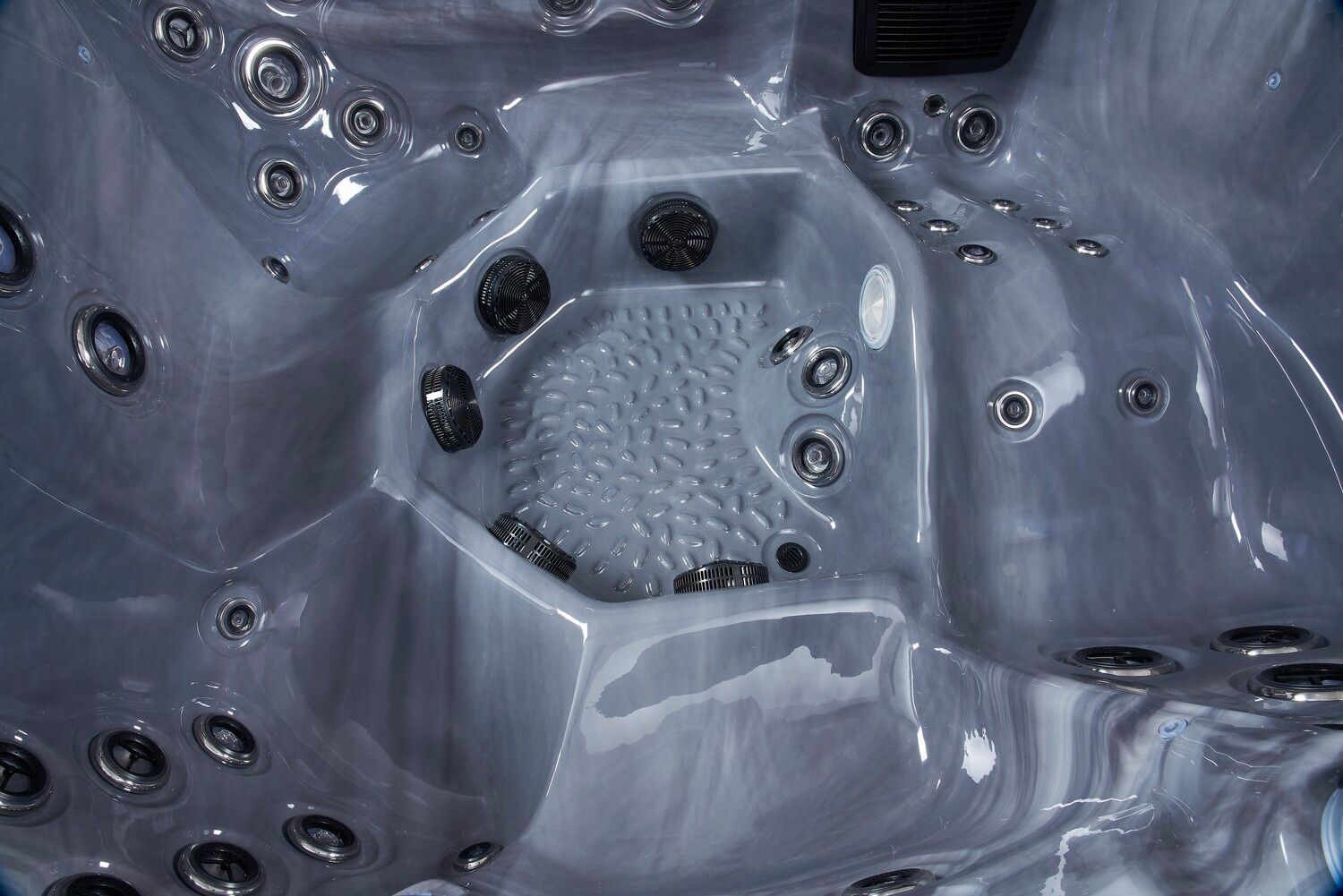 Inside a gray hot tub with multiple jet nozzles and a textured floor.
