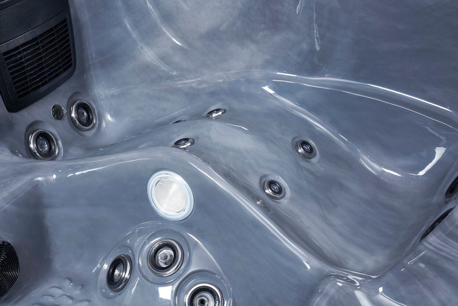 Gray hot tub interior with several jets and a light.