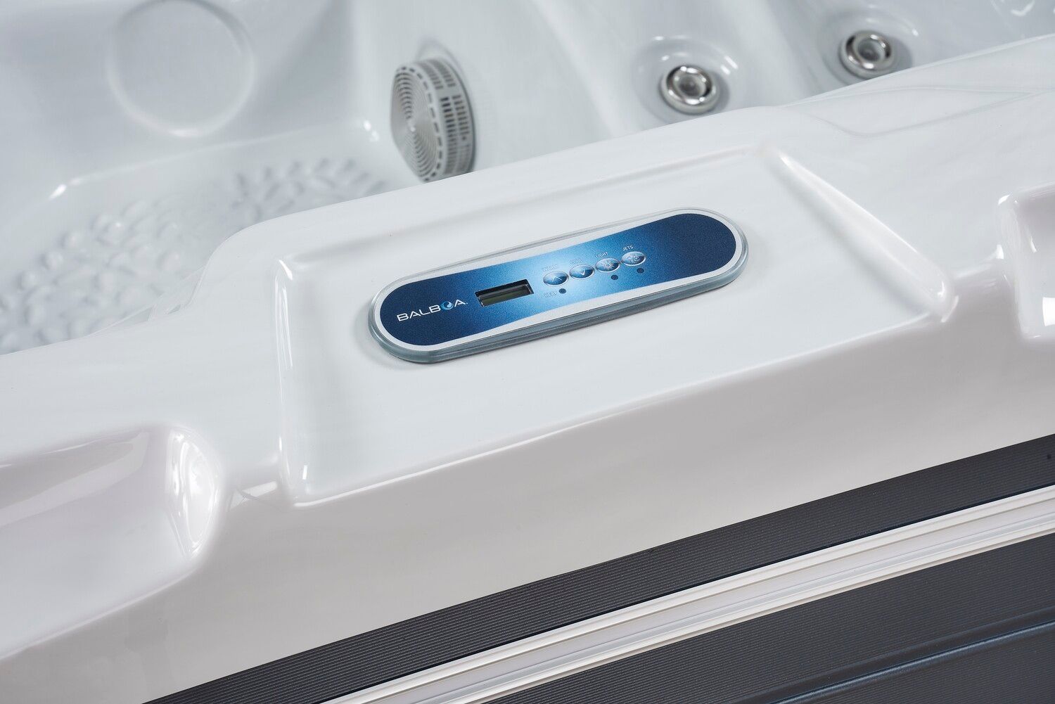 White hot tub with a blue control panel on the edge.