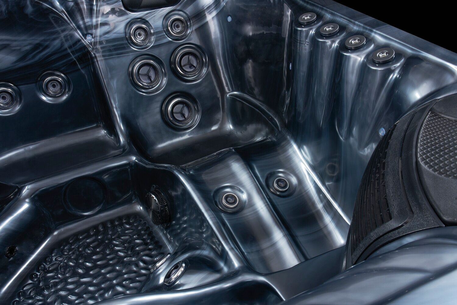 Interior view of a dark blue hot tub with jets and a person's foot visible.