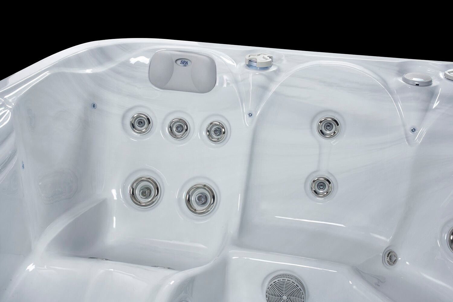 White hot tub interior with several jets and seating, against a black background.