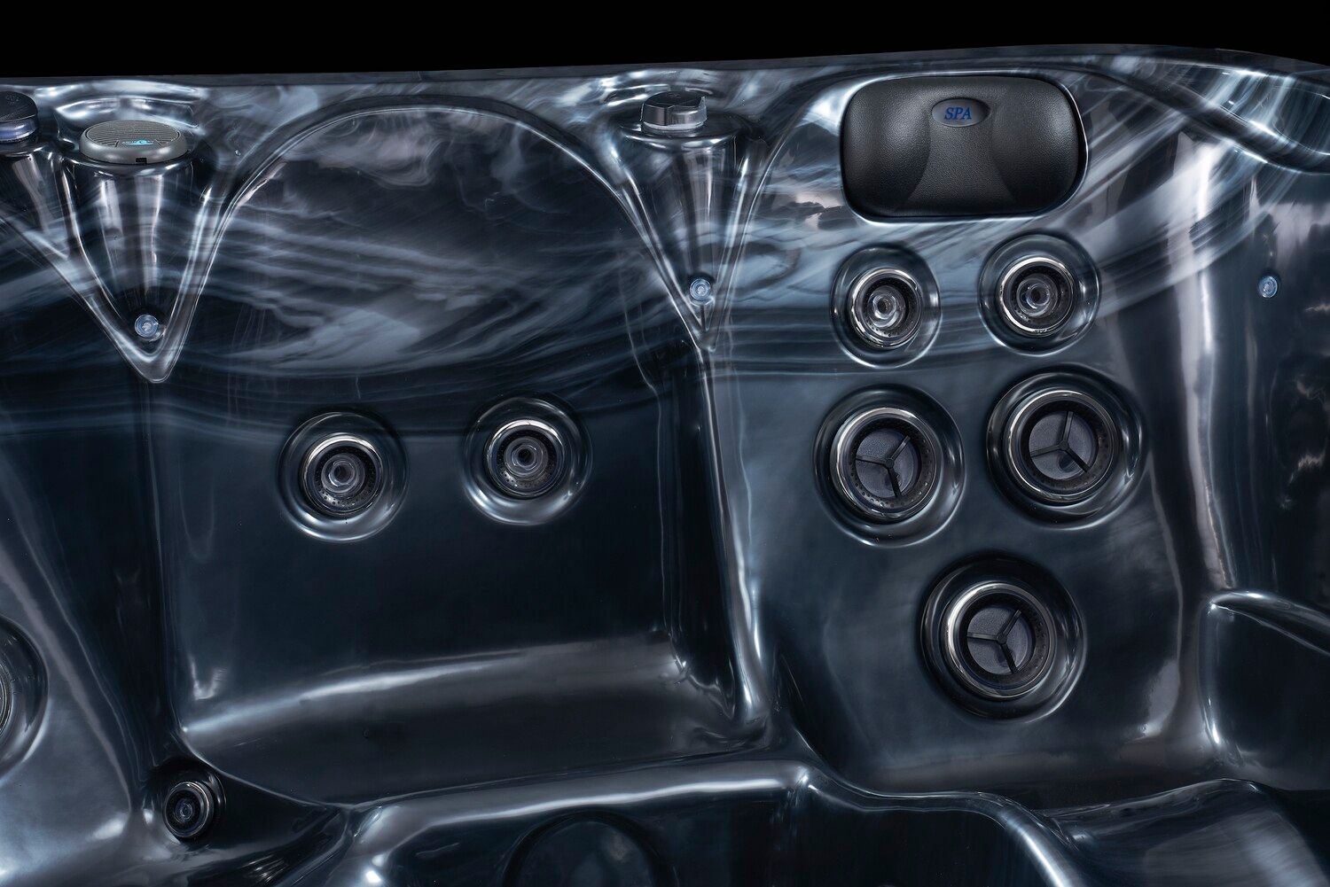 Close-up of a dark gray hot tub interior with several jet nozzles and controls.