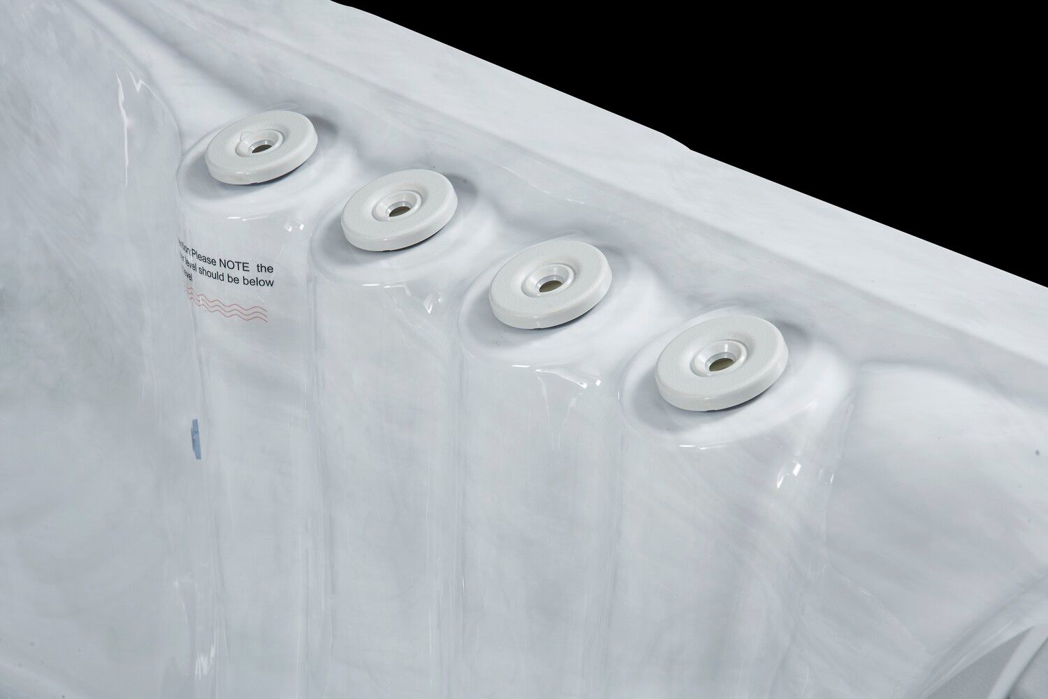 White hot tub jets along a curved white interior. Black background.