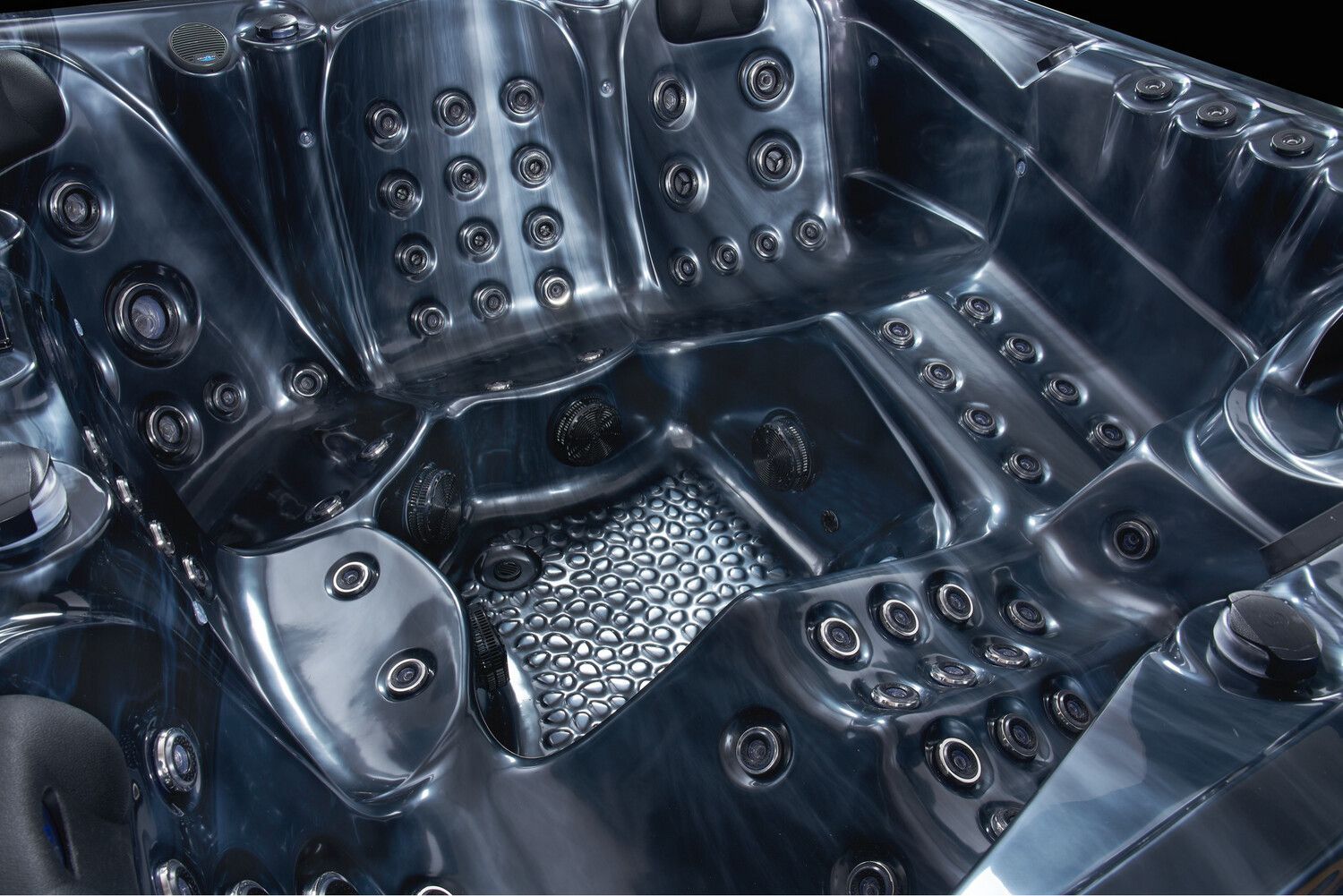 Close-up of a dark-colored hot tub interior with numerous jets and molded seating.