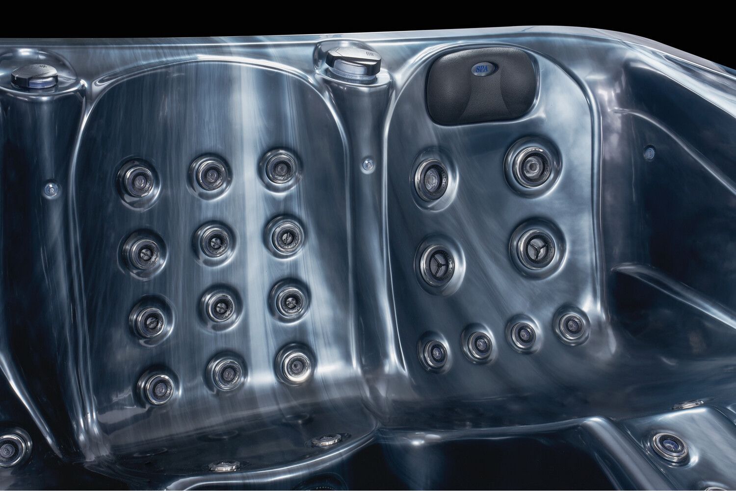 Close-up of a dark gray hot tub interior, showing multiple jets and molded seating areas.