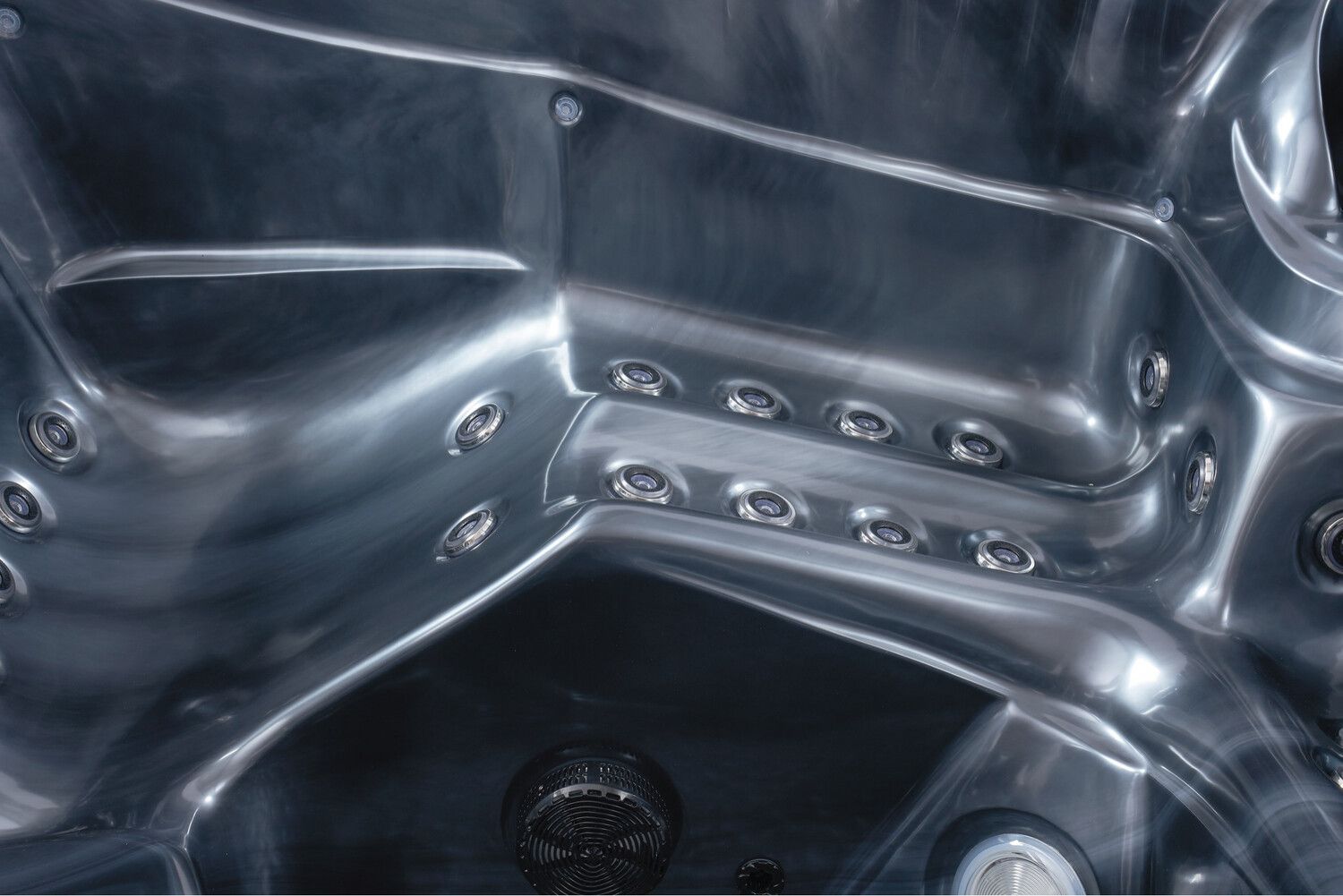 Inside view of a metallic gray hot tub with multiple jet nozzles.