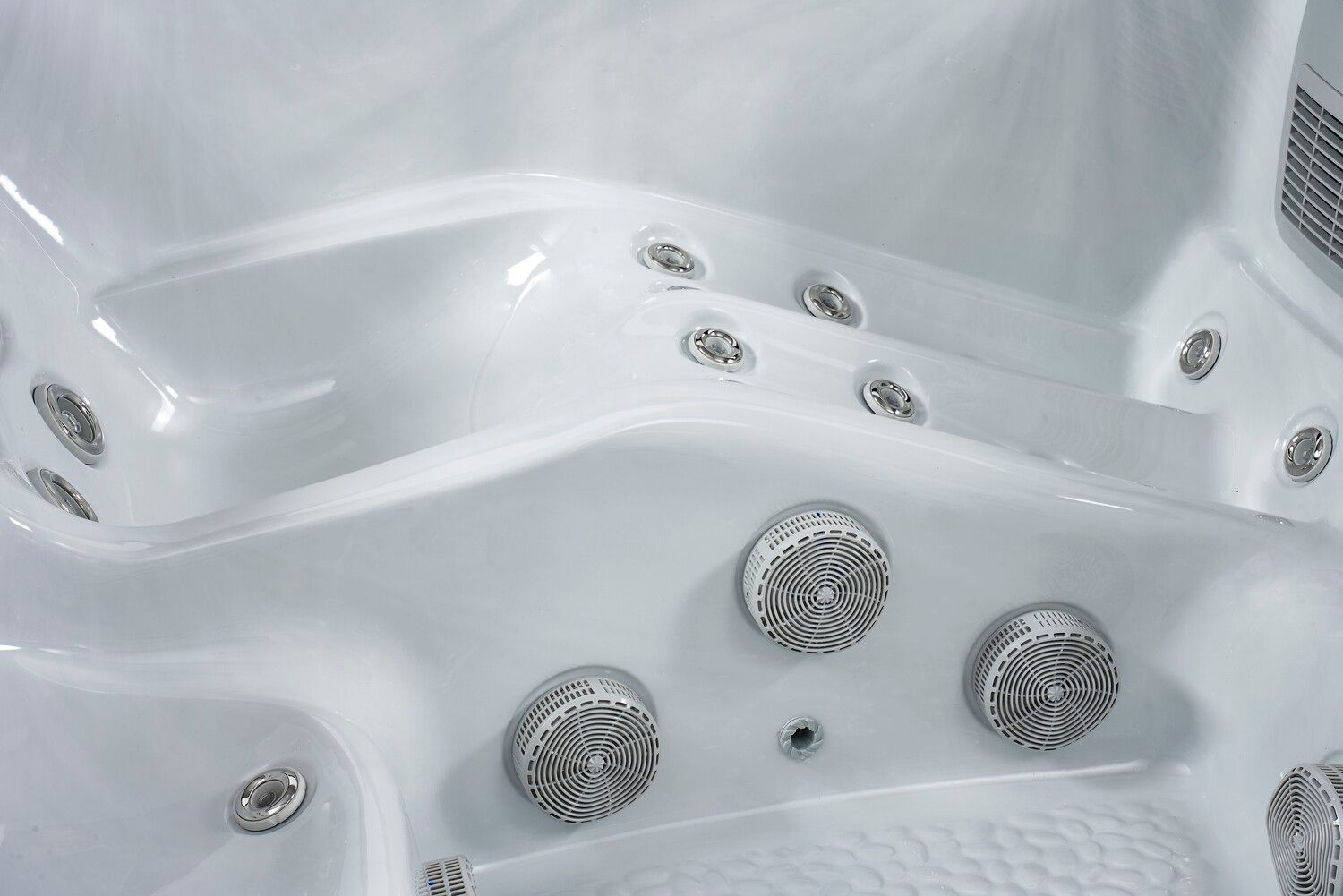 White hot tub interior with multiple jets, curved seating, and a glossy finish.