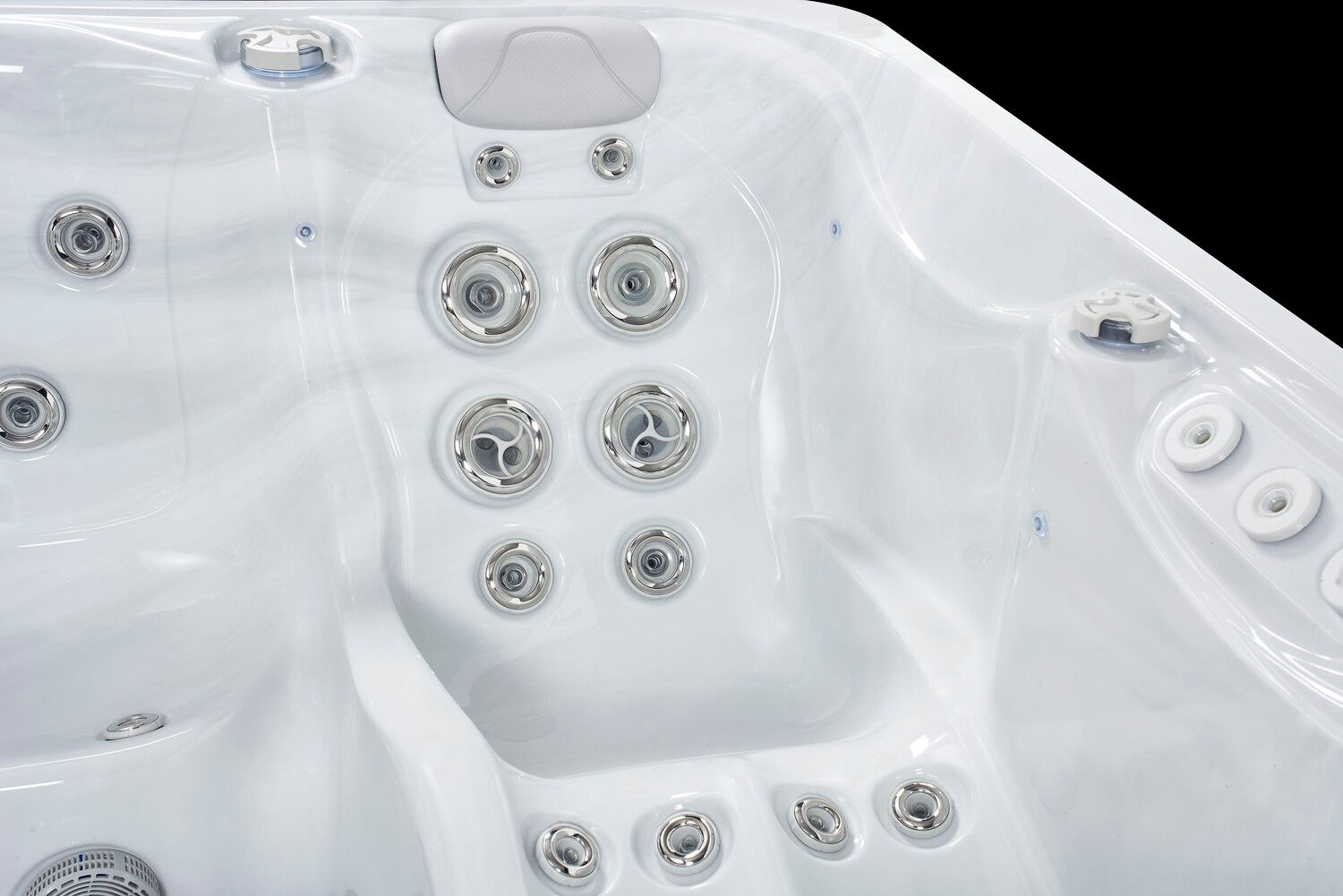 White hot tub interior with various jets, a headrest, and curved seating.