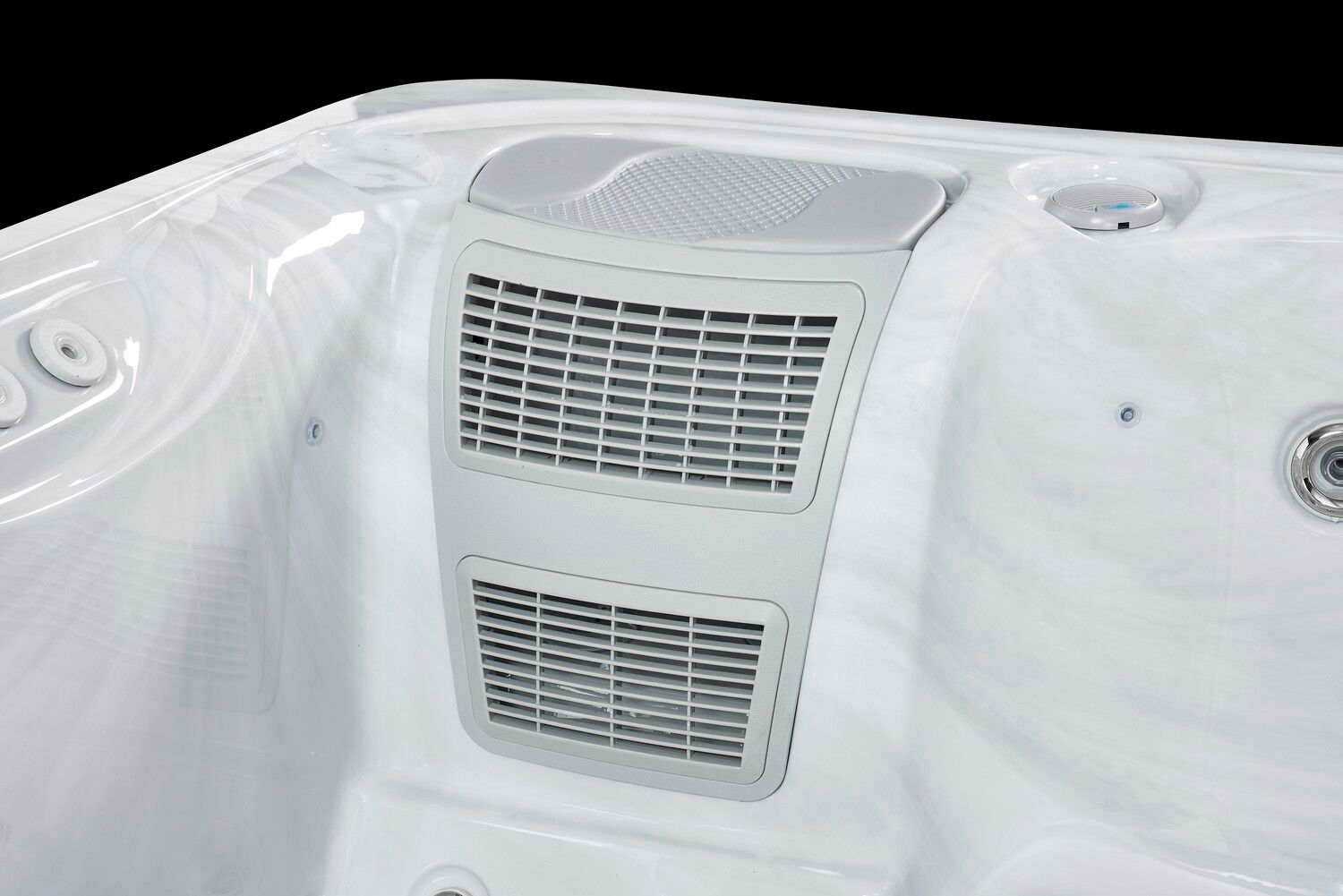 Interior detail of a white hot tub with a gray speaker and vent panel.