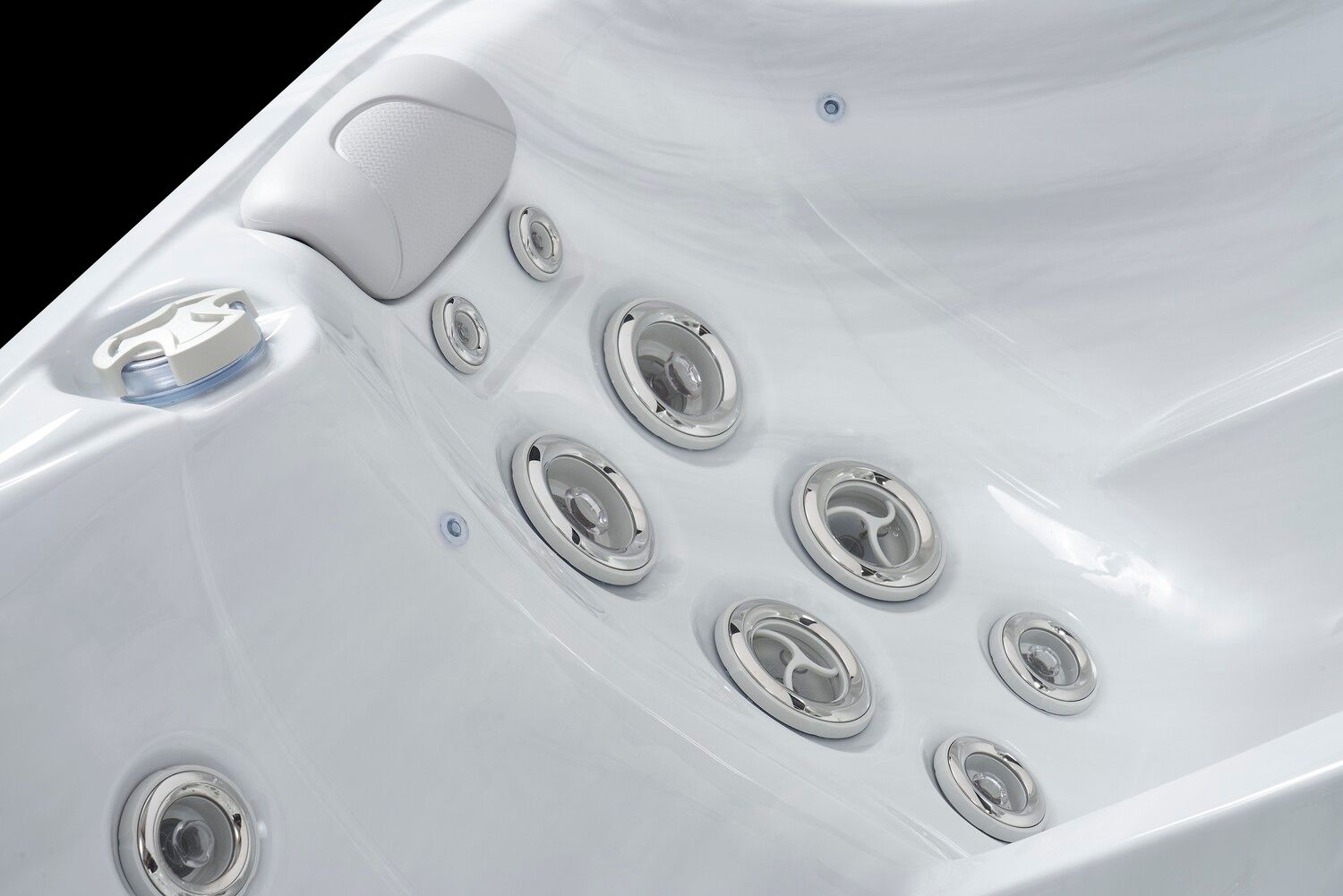 Close-up of a white hot tub interior with several silver water jets and a control panel.