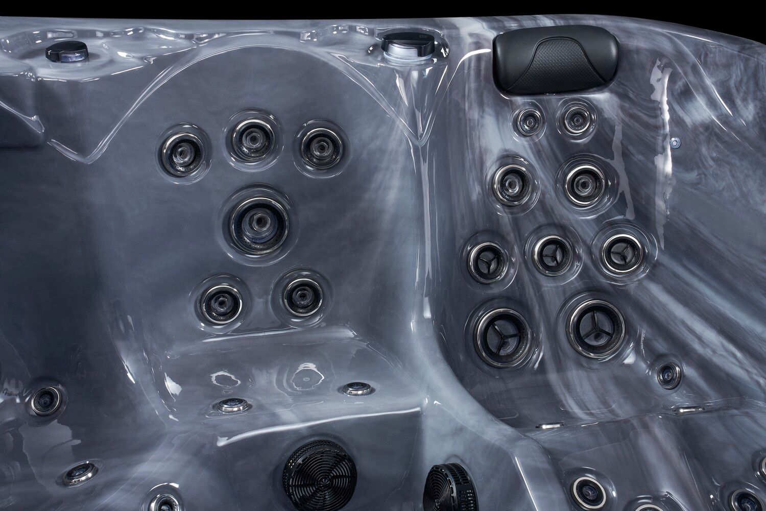 Close-up of a marbled gray hot tub interior with various jets and a headrest, against a black background.