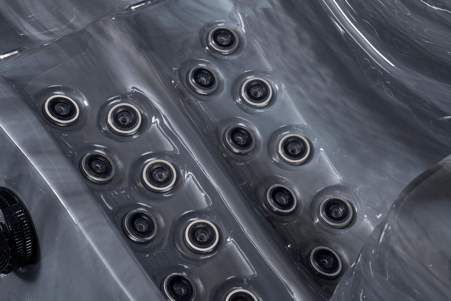 Close-up of a dark grey hot tub interior, showing multiple jet nozzles arranged in rows.