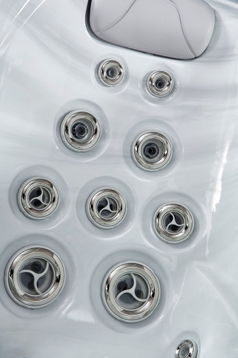 Close-up of a white hot tub interior with several silver water jets.