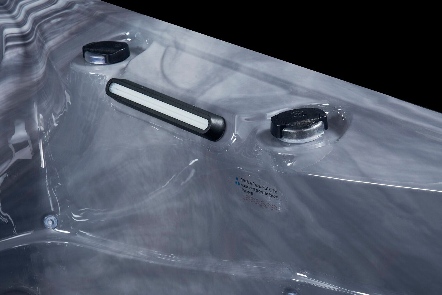 Close-up of a hot tub interior with two black capped components and a white light bar.