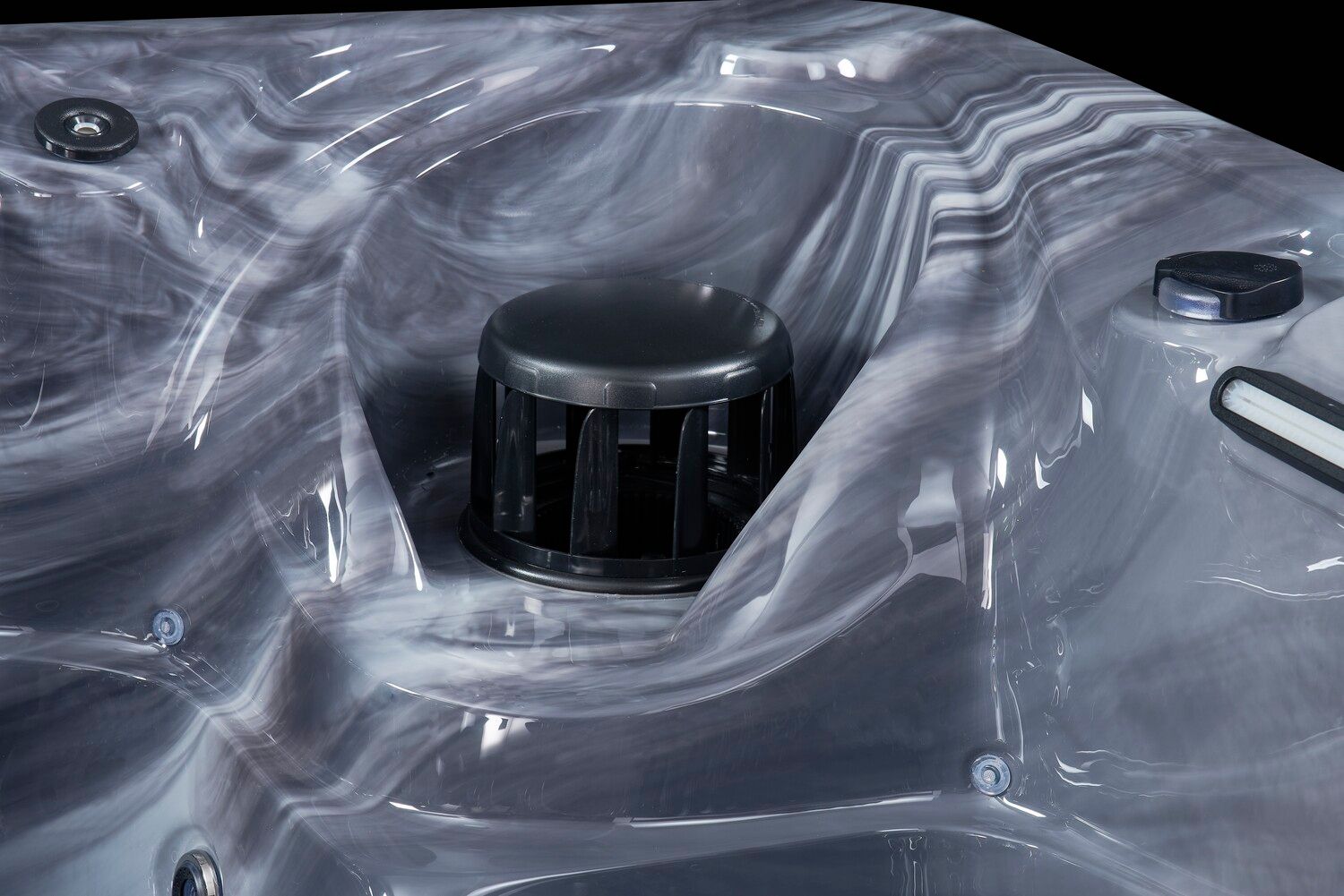 Close-up of a marbled gray hot tub interior with a black filter and jets.