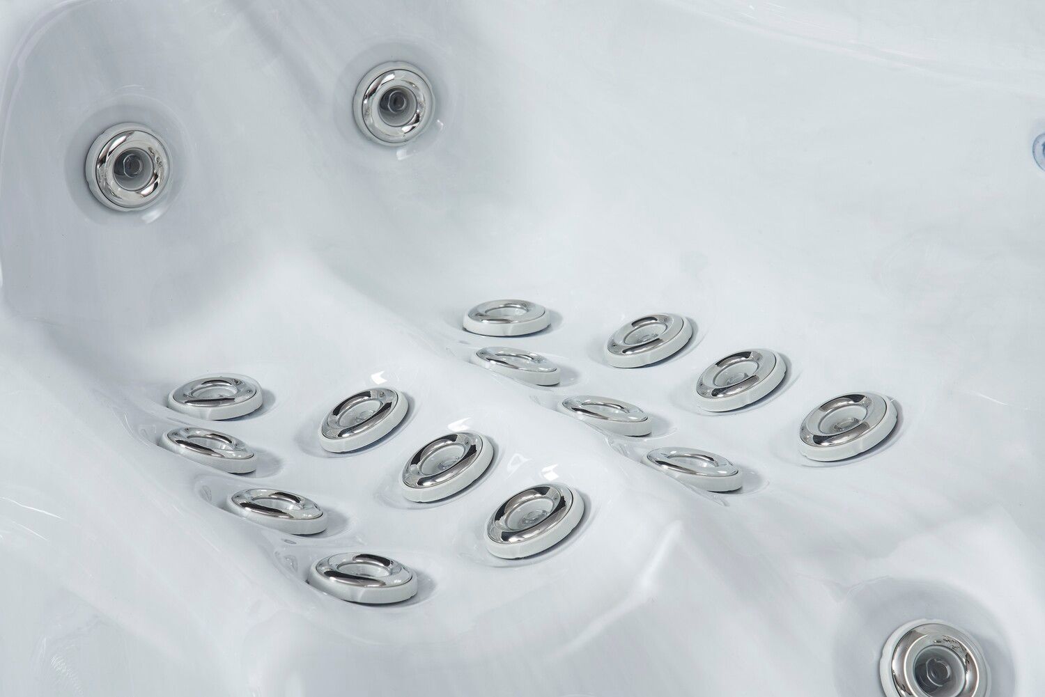 Close-up of a white hot tub interior with multiple silver jets, angled for massage.