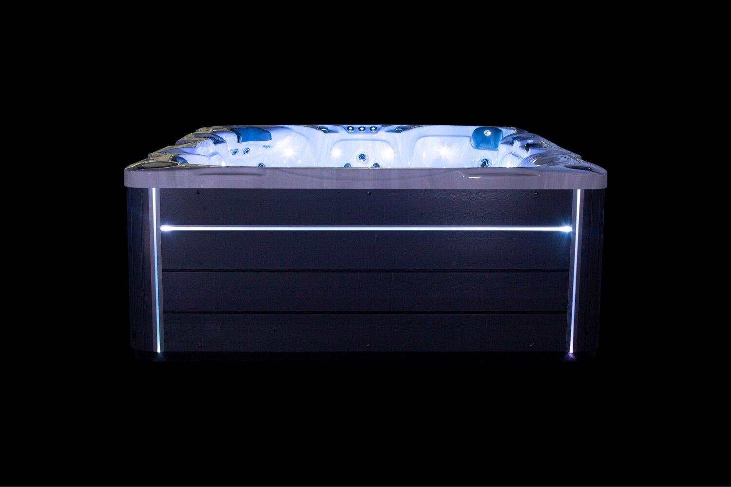 Hot tub with illuminated jets and exterior lighting, against a black background.