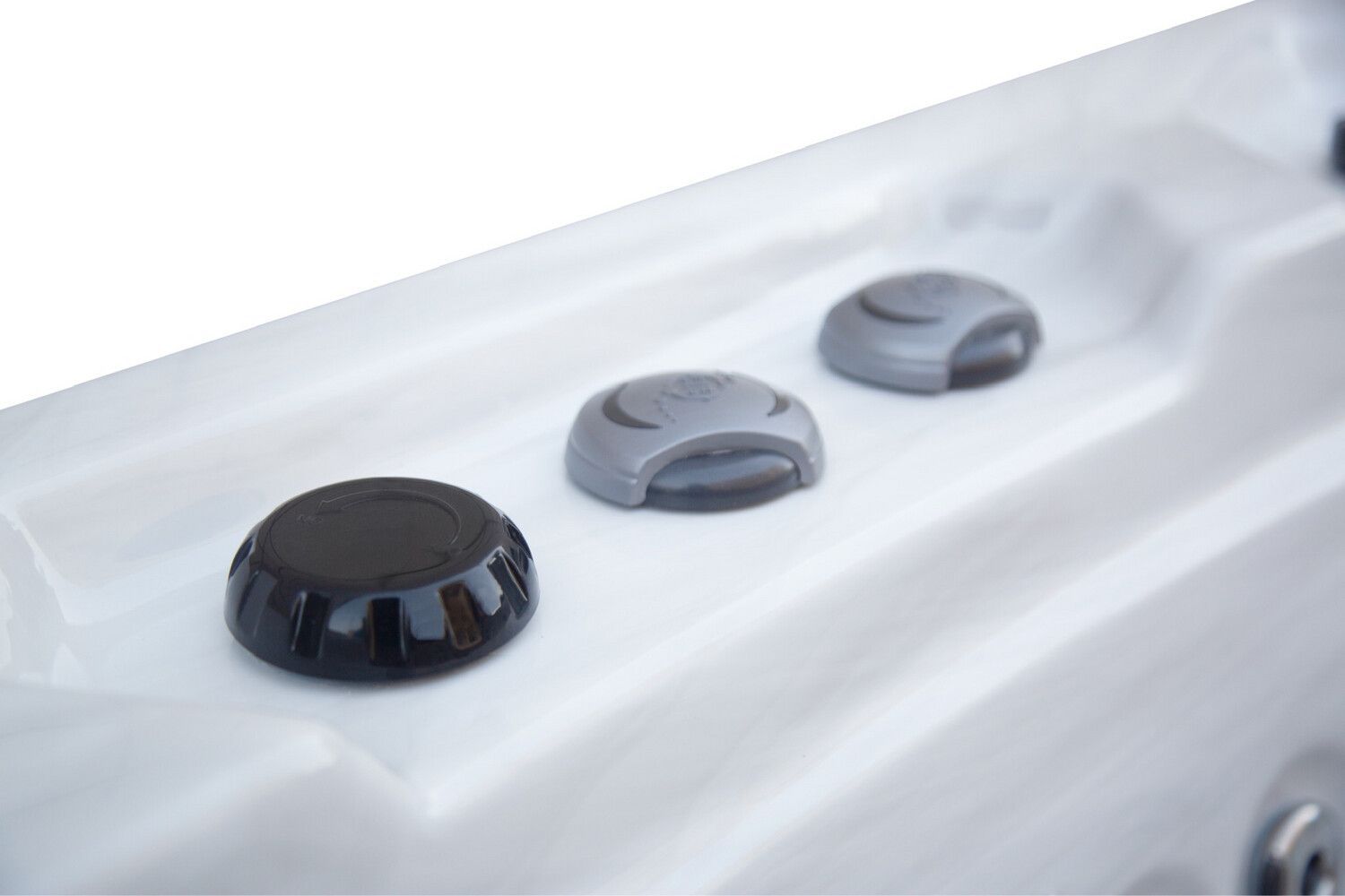 Close-up of a hot tub control panel with three buttons: one black, two gray, all on a white surface.