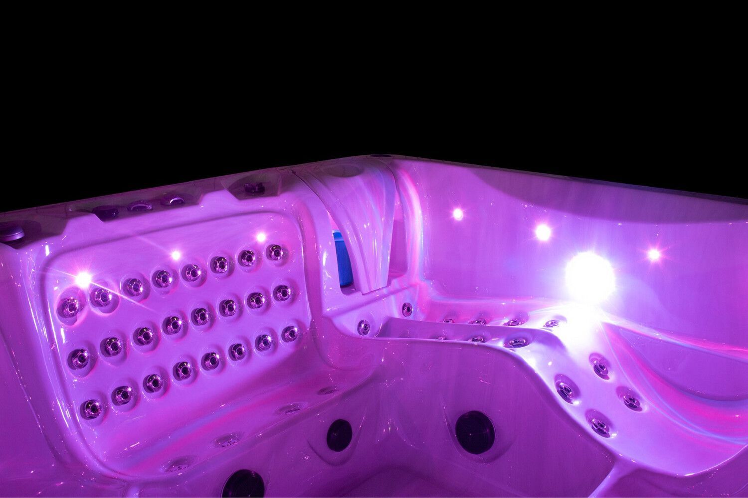 Illuminated pink hot tub interior with jets and lights against a black background.