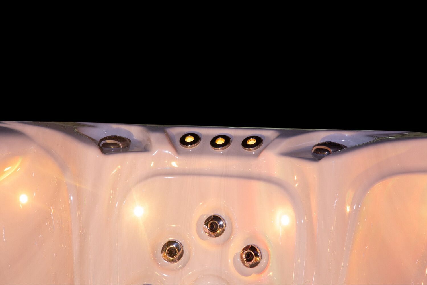 Close-up of a jacuzzi interior, featuring jets and overhead lights.