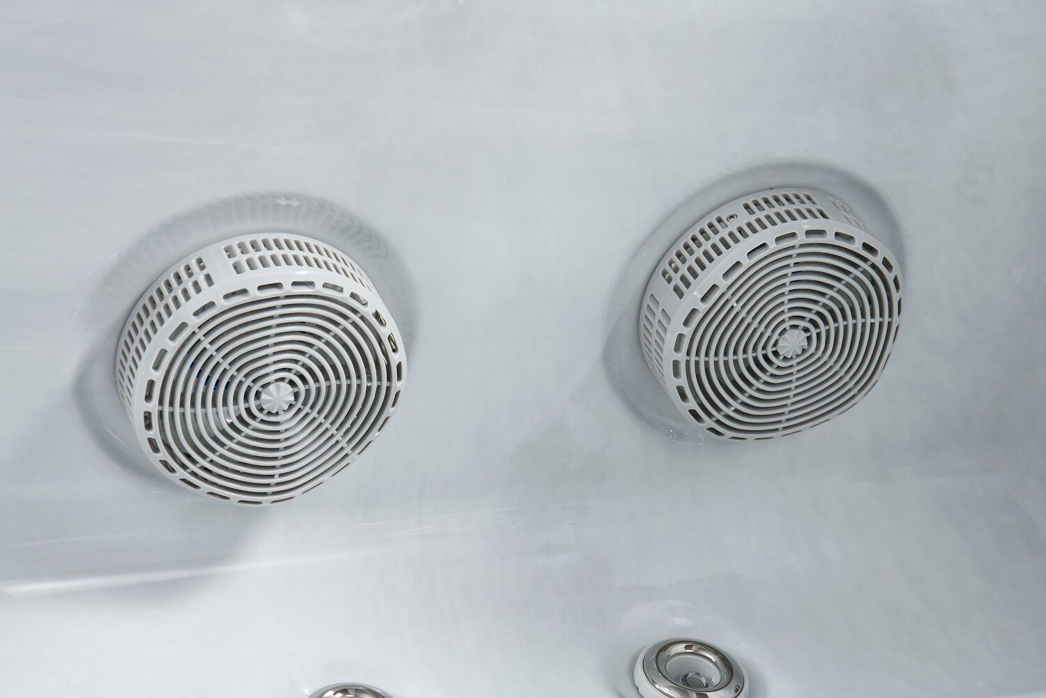 Two white circular jets inside a hot tub.