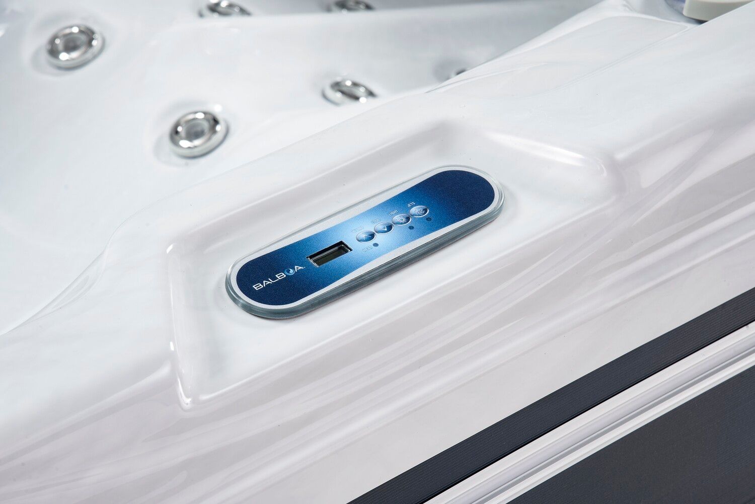 Close-up of a hot tub control panel, blue with white text, embedded in a white tub rim.
