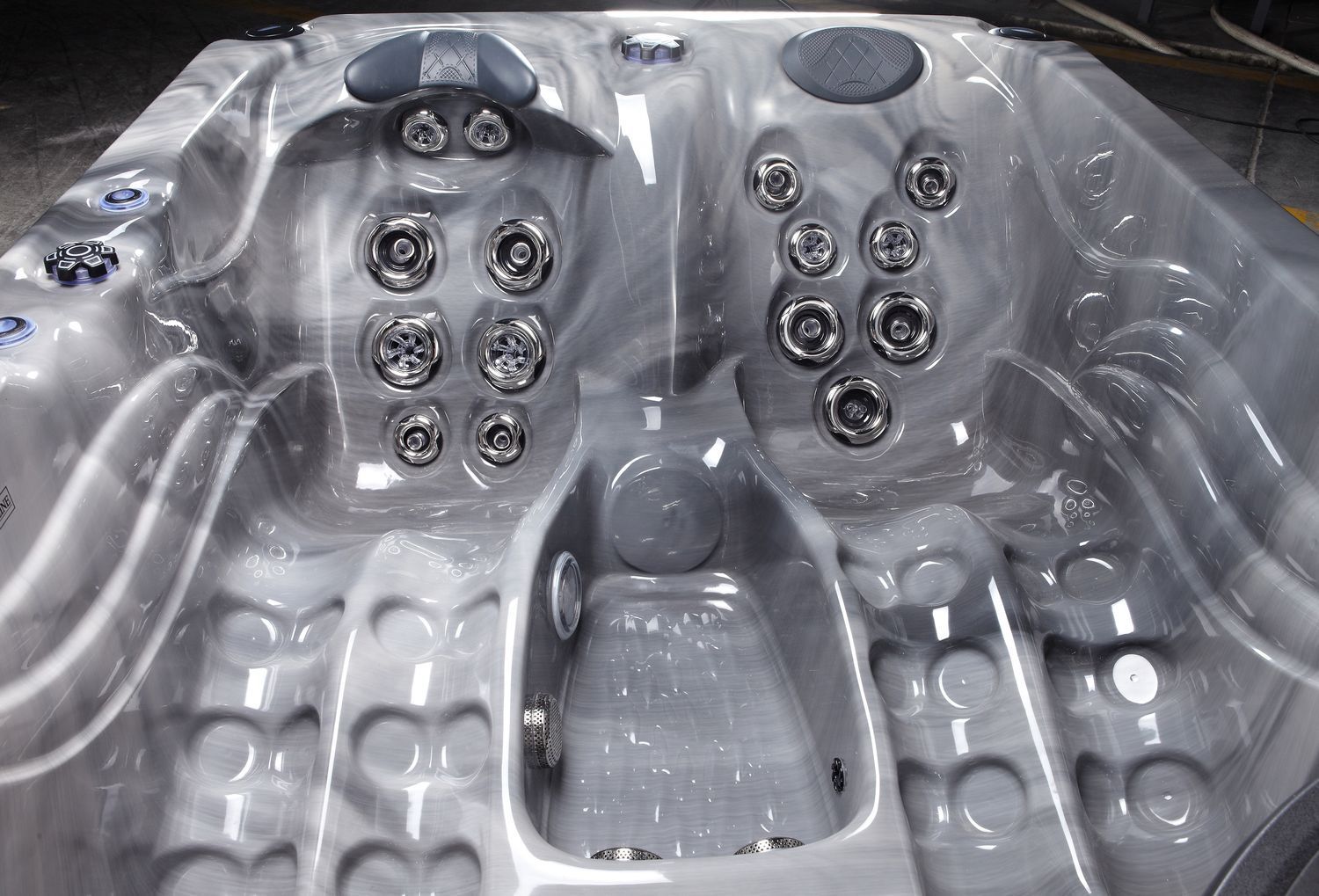 Gray and white marbled hot tub interior with multiple jets and seating areas.