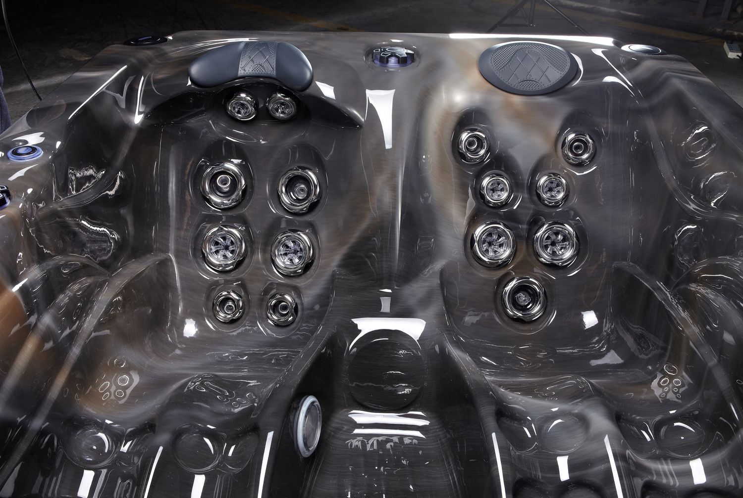 Dark-colored hot tub interior with multiple jets and seating areas.