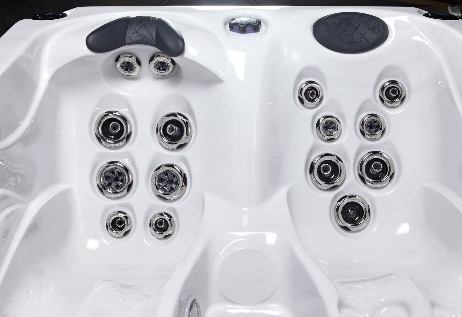 White hot tub interior with multiple jet nozzles and headrests.