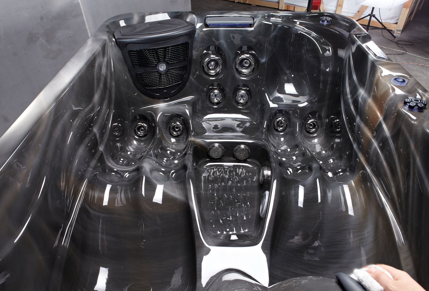 Black hot tub interior with jets, control panel, and footwell.