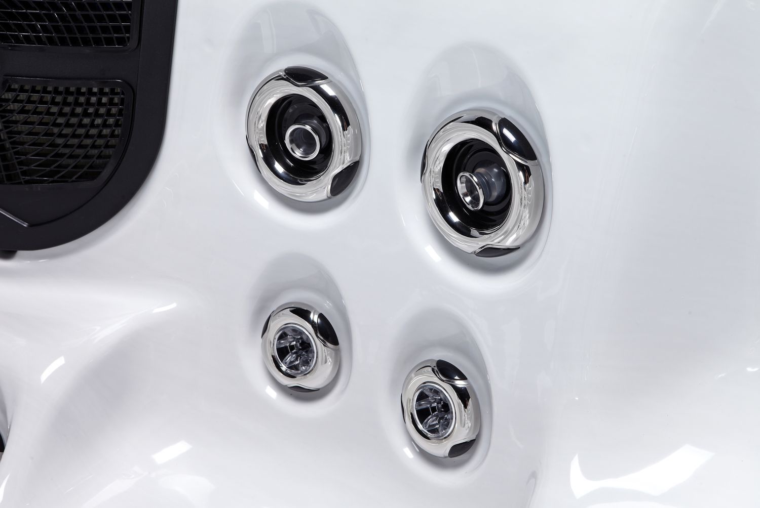 Close-up of a white hot tub interior with four chrome jets.