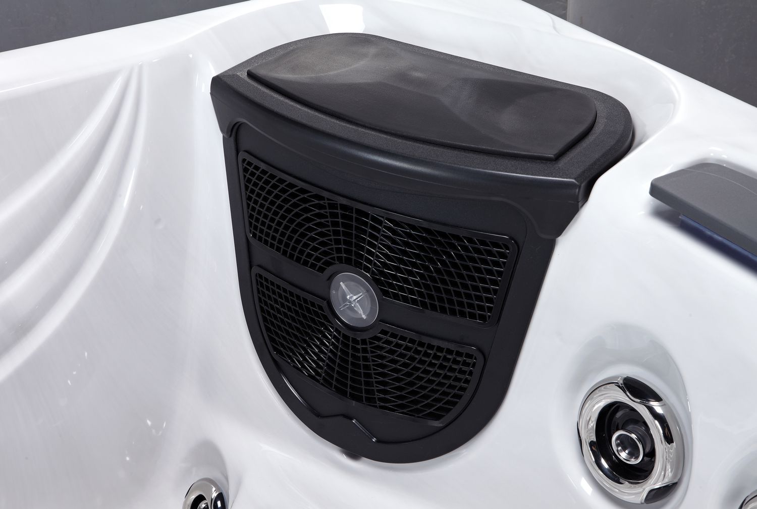 Black speaker panel in a white hot tub, with jets visible.