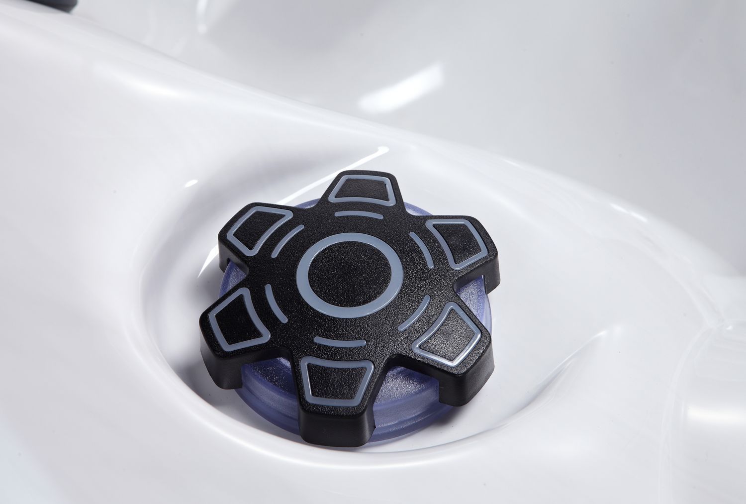 Black and gray hot tub control knob set in a white tub.