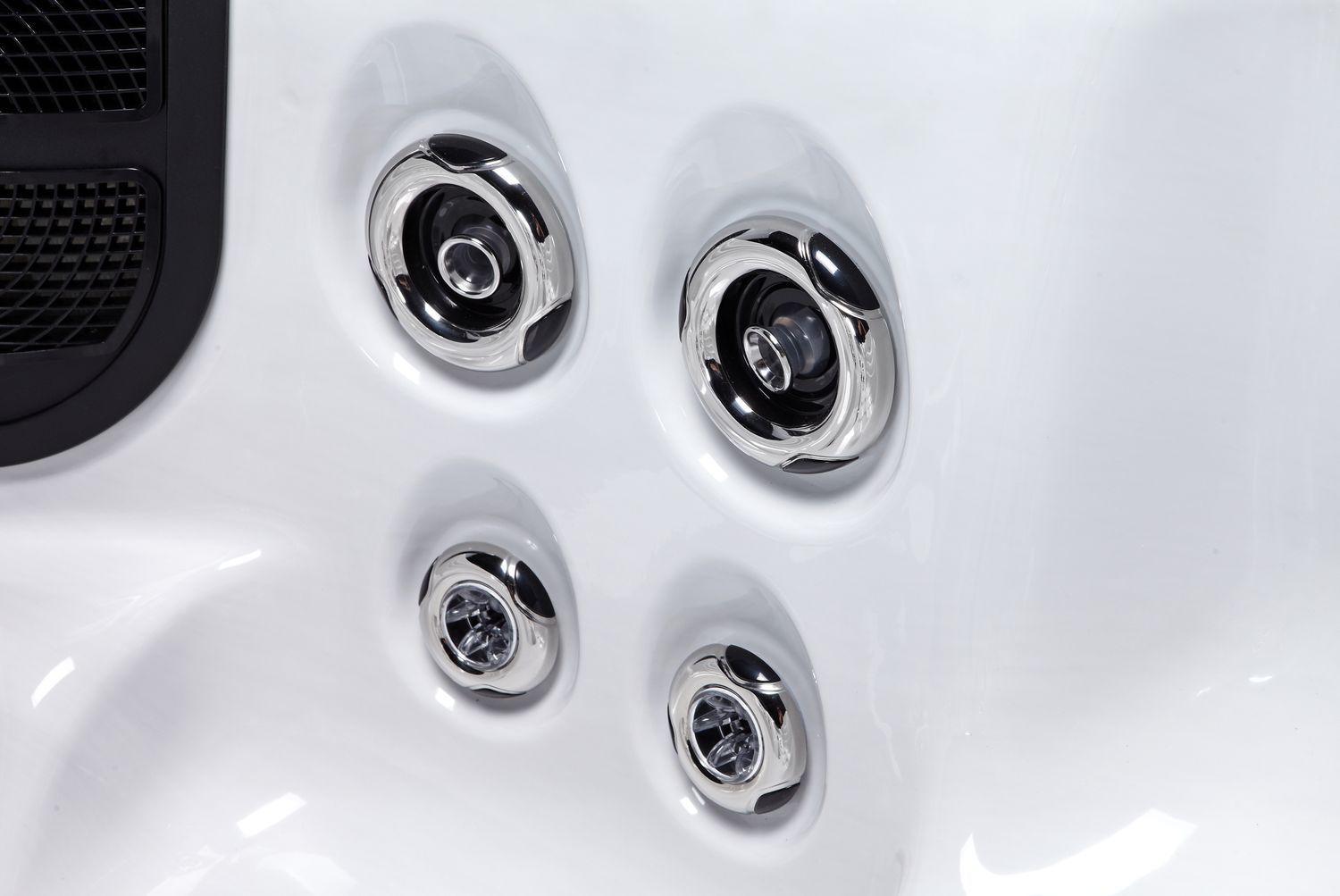 Close-up of four silver hot tub jets against a white interior.