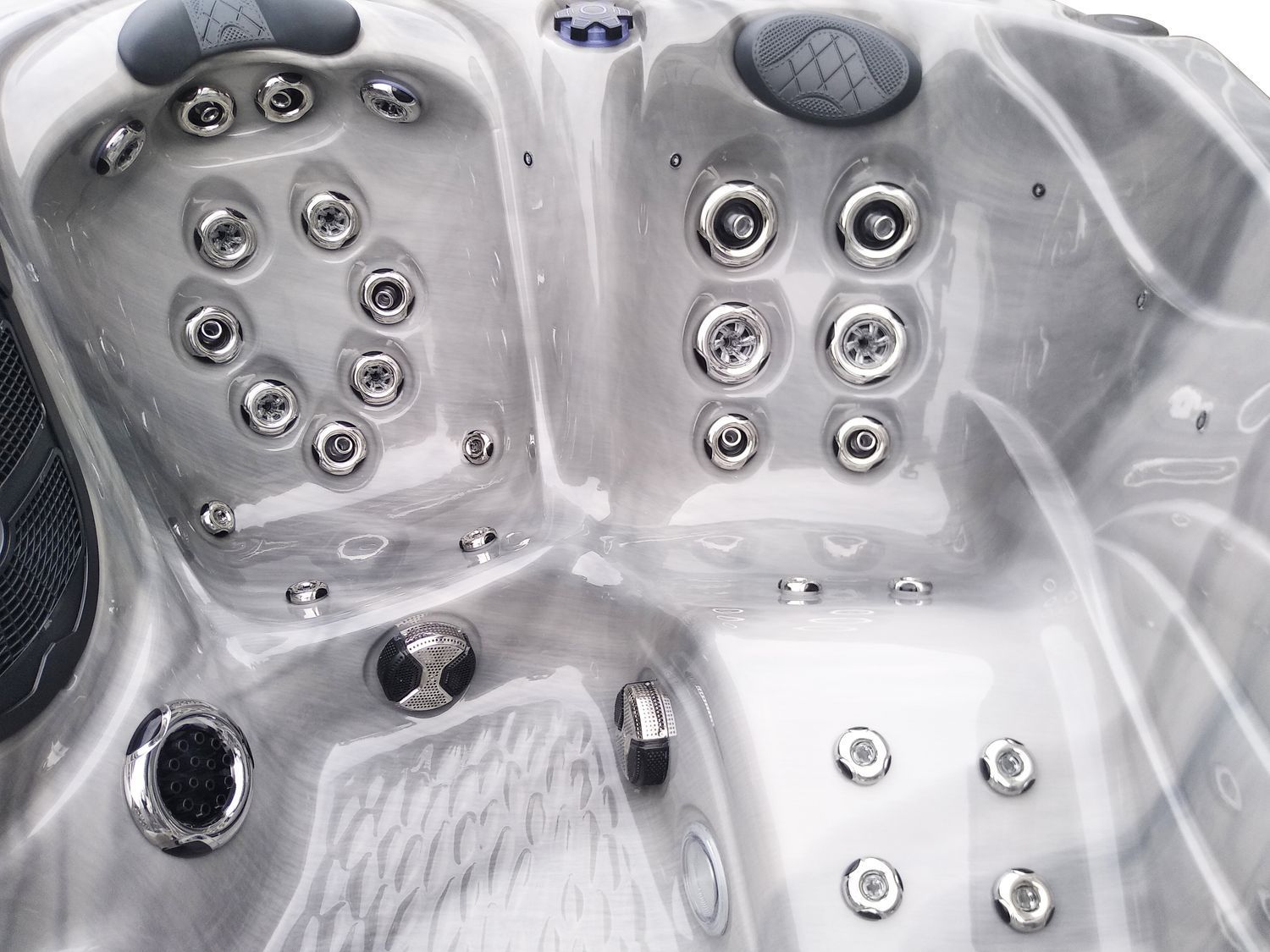 Close-up of a white hot tub interior, showing multiple silver jets and water features.