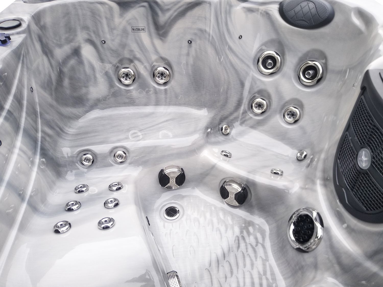 Interior view of a marbled gray hot tub with multiple jets.