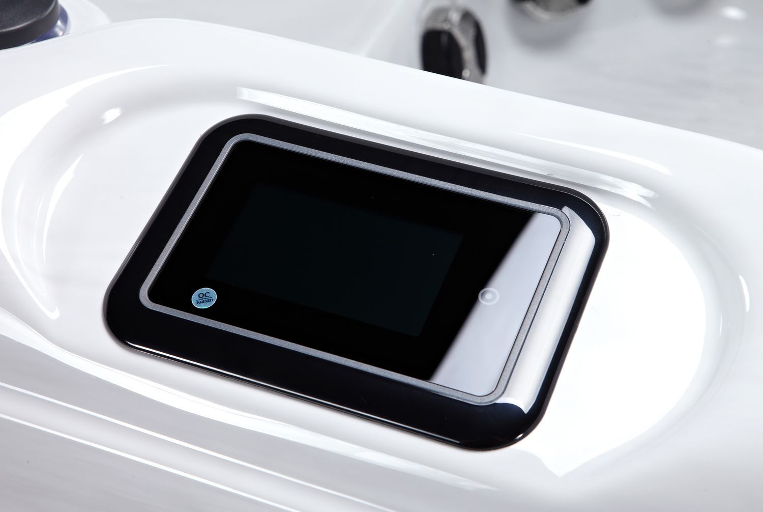 Black rectangular control panel with blank screen set in a white tub.