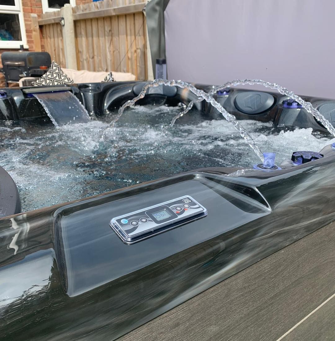 Hot tub with water jets and control panel.