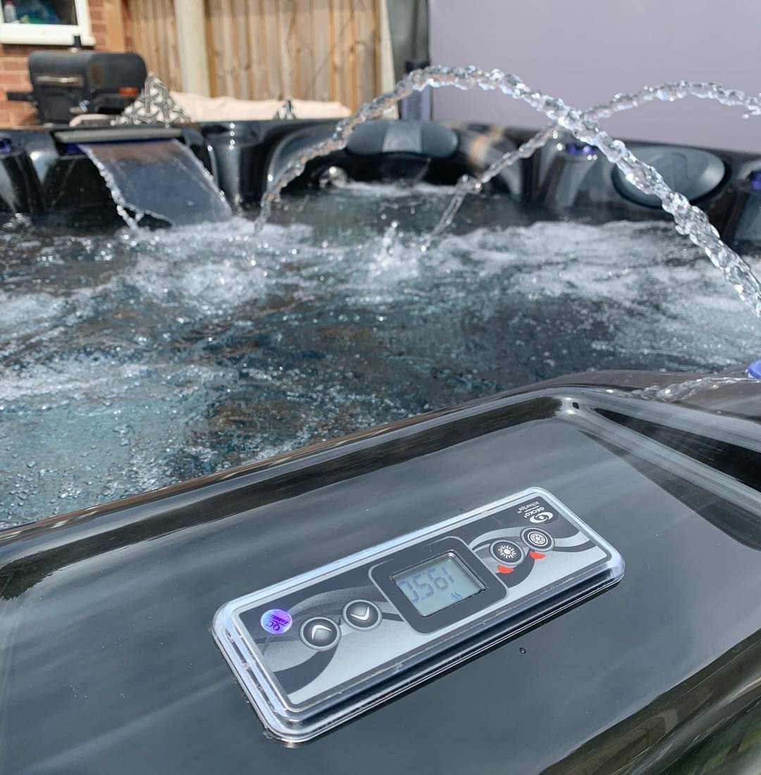 Hot tub with bubbling water and control panel; outdoors.