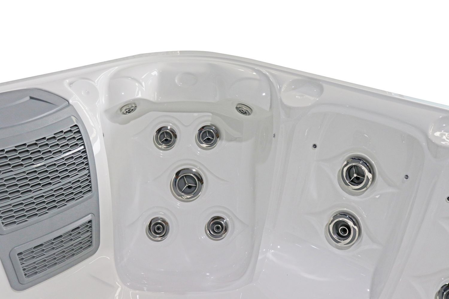 Close-up of a white hot tub interior, showing multiple water jets and a grey speaker.