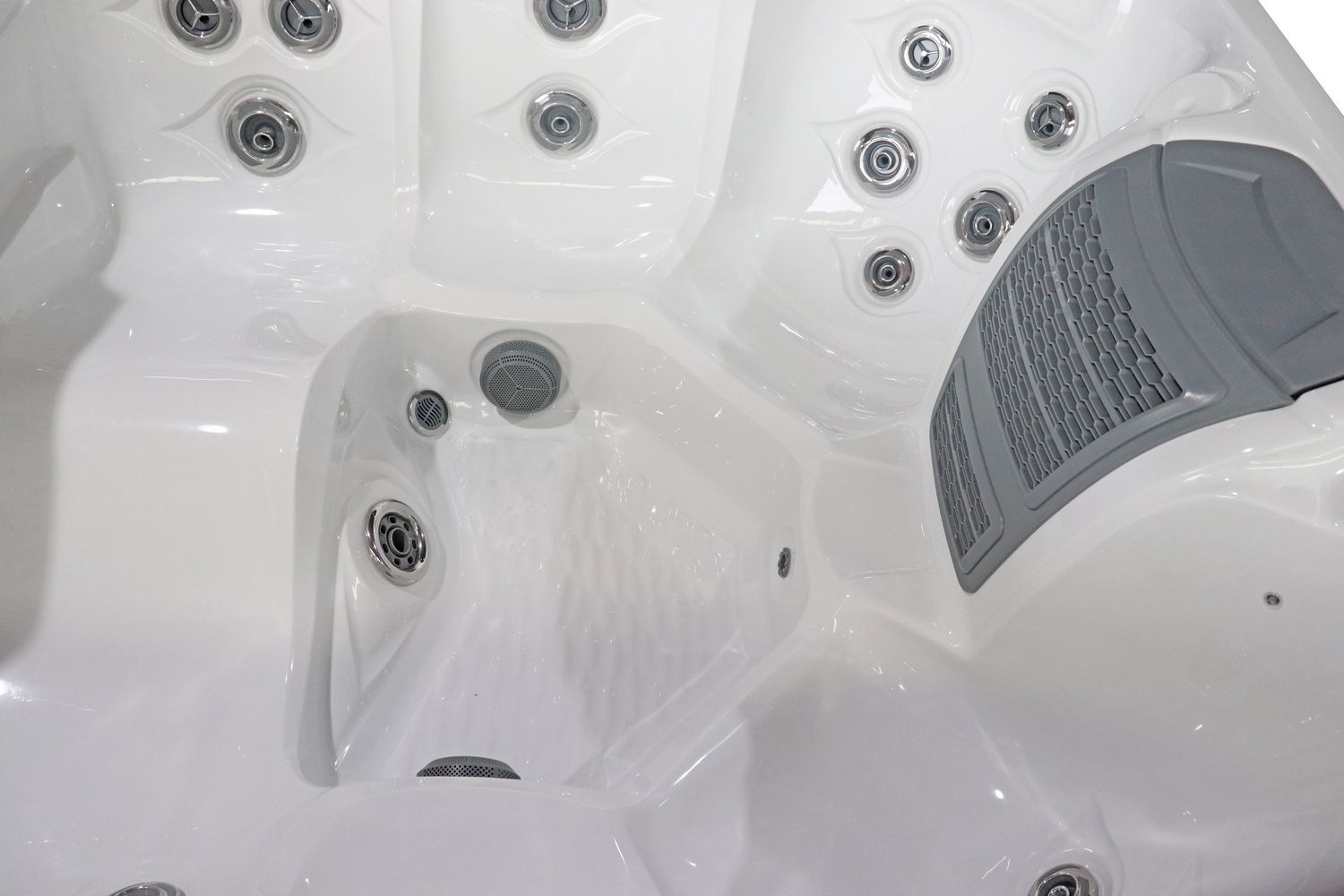 White hot tub interior with multiple jets and gray panel.