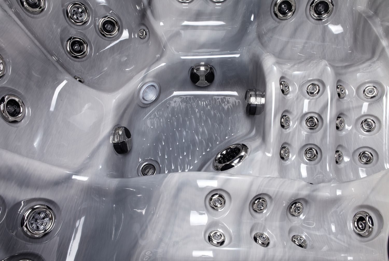 Grey and white marbled hot tub interior with numerous jets.