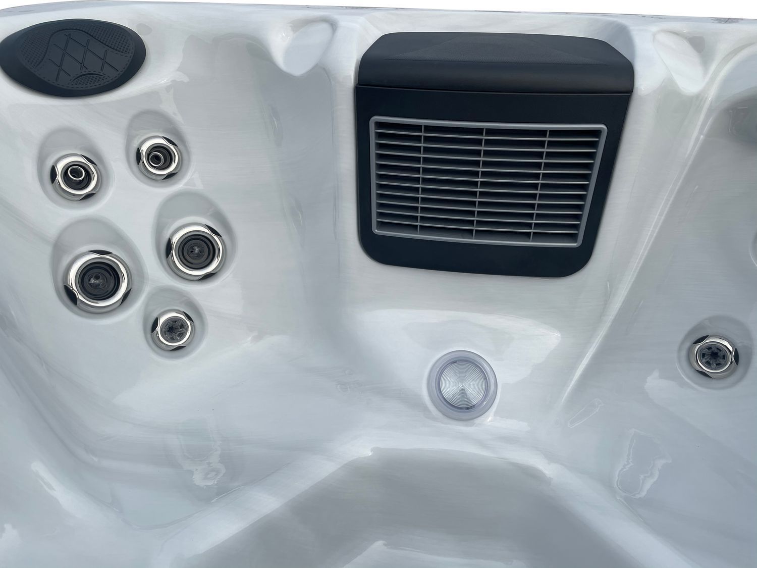 Close-up of a hot tub interior with jets and a vent in white and gray plastic.