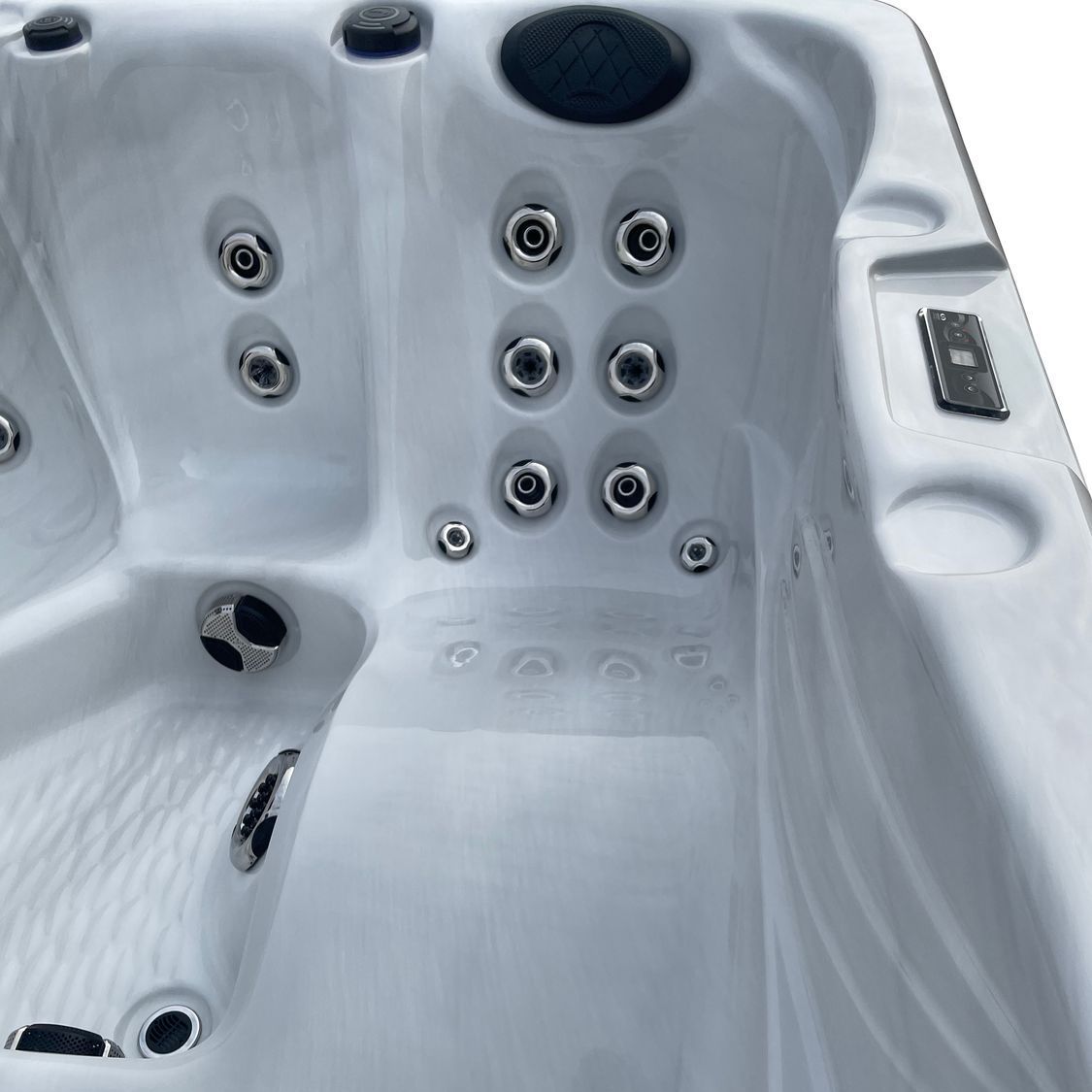 White hot tub interior with jets, control panel, and cup holders.