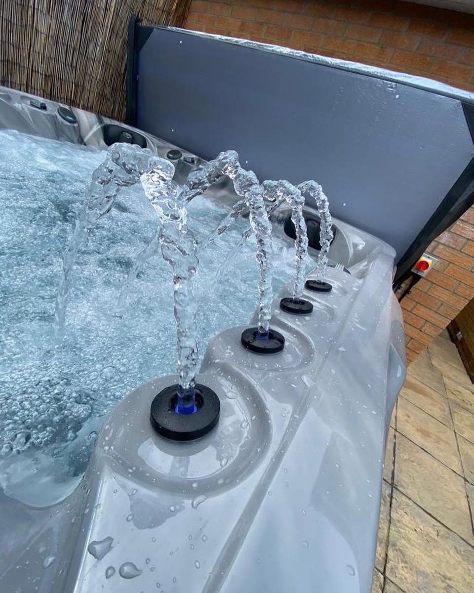 Close-up of a hot tub with multiple jets spraying water into the bubbling water.