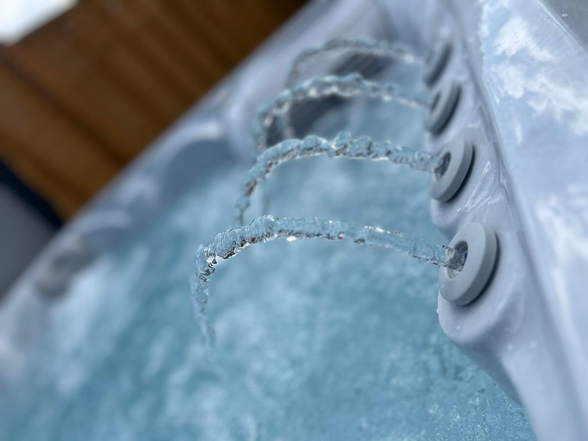 Close-up of a hot tub with water jets spraying into the bubbly water.
